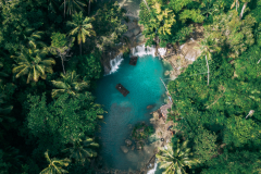 Beautiful waterfall streaming into the river surrounded by greens